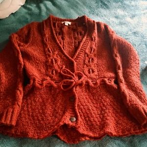 Orangish/reddish button up sweater.